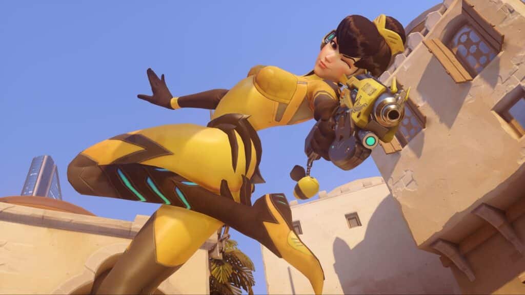 B.Va in a dynamic yellow and brown suit strikes a playful pose with one arm out and a wink